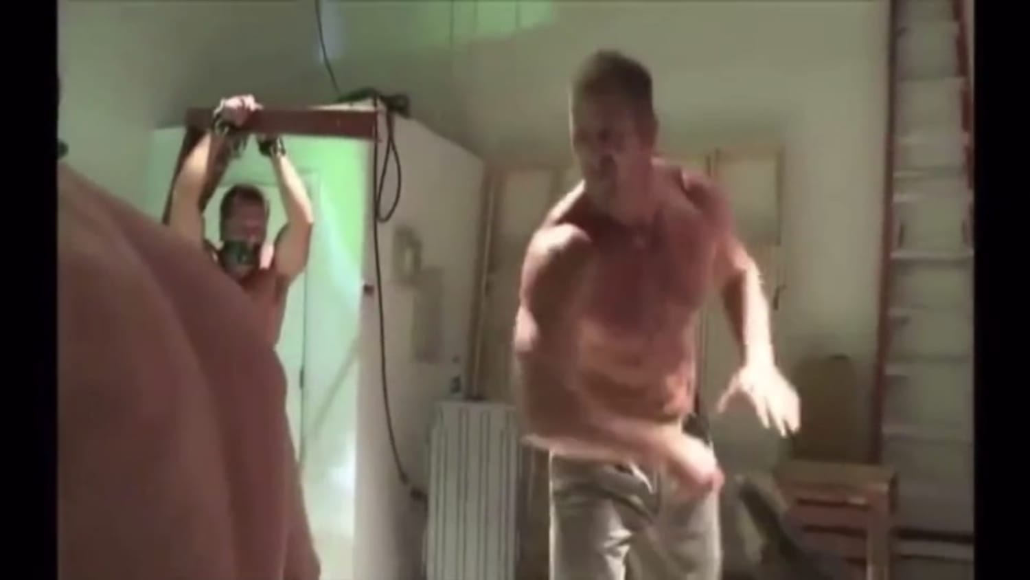 Shirtless Muscle Dom Whips a group of subs